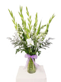 This alluring arrangement is full of elegance and class. With gorgeous white Snapdragons, ethereal green Gladiolus, beautiful soft filler and greenery.