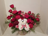 Introducing a fresh design for the beloved holiday dog! Crafted with vibrant carnations and aromatic greens, complete with a charming hat, this cheerful canine embodies the essence of the season. Sending this arrangement is a delightful way to extend warm wishes of "Merry Everything!" to your cherished ones.