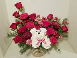 Introducing a fresh design for the beloved holiday dog! Crafted with vibrant carnations and aromatic greens, complete with a charming hat, this cheerful canine embodies the essence of the season. Sending this arrangement is a delightful way to extend warm wishes of "Merry Everything!" to your cherished ones.