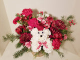 Introducing a fresh design for the beloved holiday dog! Crafted with vibrant carnations and aromatic greens, complete with a charming hat, this cheerful canine embodies the essence of the season. Sending this arrangement is a delightful way to extend warm wishes of "Merry Everything!" to your cherished ones.